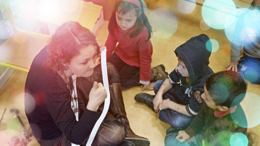 Photo d'une enseignante en classe de maternelle avec ses élèves, avec effet lumineux | Crédit : INSPE